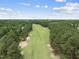 Scenic aerial view of the lush green golf course surrounded by trees and a bright blue sky at 1300 Heritage Club Ave, Wake Forest, NC 27587