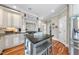 Spacious kitchen with hardwood floors, ample white cabinetry, stainless steel appliances, and a center island at 1300 Heritage Club Ave, Wake Forest, NC 27587