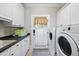 Clean laundry room features front load washer/dryer, utility sink, and storage cabinets at 1300 Heritage Club Ave, Wake Forest, NC 27587