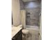 Tiled bathroom features a shower with a built-in shelf and a white bathtub, complete with modern fixtures at 1357 Prevenient Dr, Wake Forest, NC 27587