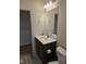 Elegant bathroom featuring a dark vanity cabinet, a rectangular mirror, and modern towel rings on the wall at 1357 Prevenient Dr, Wake Forest, NC 27587