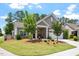 Charming home with a well-manicured lawn and tasteful landscaping, featuring stone accents and a cozy front porch at 1357 Prevenient Dr, Wake Forest, NC 27587