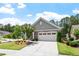 Charming home exterior with gray siding, stone accents, and lush landscaping at 1357 Prevenient Dr, Wake Forest, NC 27587