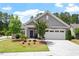 Inviting exterior featuring a well-kept lawn, mature trees, and charming architectural details at 1357 Prevenient Dr, Wake Forest, NC 27587