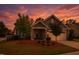Charming home featuring manicured landscaping, a two-car garage, and a cozy front porch at sunset at 1357 Prevenient Dr, Wake Forest, NC 27587