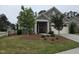 Attractive home showcasing manicured landscaping, stone accents, and a cozy front porch with rocking chairs at 1357 Prevenient Dr, Wake Forest, NC 27587
