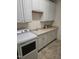 Well-appointed laundry room with white cabinets, a utility sink, countertops, and modern appliances at 1357 Prevenient Dr, Wake Forest, NC 27587