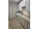 Bright laundry room with white cabinets, countertop, washer and dryer hookups, and tiled flooring at 1357 Prevenient Dr, Wake Forest, NC 27587