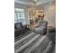 Comfortable living room featuring modern furniture, wood-look flooring, and an open layout to the kitchen at 1357 Prevenient Dr, Wake Forest, NC 27587