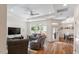 Comfortable living room with hardwood floors, a ceiling fan, and ample natural light with an open floor plan at 1357 Prevenient Dr, Wake Forest, NC 27587