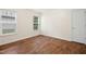 Well-lit bedroom features hardwood flooring, neutral walls, and two bright windows at 1506 Golden Bell Dr, Raleigh, NC 27610