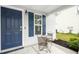 Cozy covered front porch features a table and chairs next to a blue front door at 1506 Golden Bell Dr, Raleigh, NC 27610