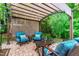 Charming backyard patio featuring comfortable blue chairs under a pergola with chandelier, perfect for outdoor relaxation at 1577 Tice Hurst Ln, Apex, NC 27502