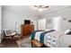 Comfortable bedroom with hardwood floors, dresser, and a cozy seating area at 1577 Tice Hurst Ln, Apex, NC 27502