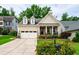 Charming home featuring a two-car garage, front porch, and well-manicured landscaping at 1577 Tice Hurst Ln, Apex, NC 27502