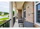 Cozy front porch featuring brick columns, black railings, and comfortable seating at 1577 Tice Hurst Ln, Apex, NC 27502