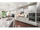 Modern kitchen with granite countertops, stainless steel appliances, and sleek white cabinetry at 1577 Tice Hurst Ln, Apex, NC 27502