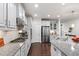 Bright kitchen featuring white cabinets, granite countertops, and stainless steel appliances at 1577 Tice Hurst Ln, Apex, NC 27502
