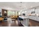 Open-concept living room with stone fireplace, kitchen island, and hardwood floors at 1577 Tice Hurst Ln, Apex, NC 27502