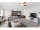 Upstairs living room with ceiling fan, sofa, TV, and shelving at 1577 Tice Hurst Ln, Apex, NC 27502