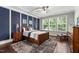 Tranquil main bedroom featuring large windows, tray ceiling, and ample natural light at 1577 Tice Hurst Ln, Apex, NC 27502