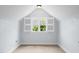 Cozy attic space featuring a window with open shutters for natural light, and soft carpeted floors at 1633 Lakestone Village Ln, Fuquay Varina, NC 27526