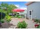 Landscaped backyard with brick patio, red canopy, and well-maintained garden beds, perfect for outdoor gatherings at 1633 Lakestone Village Ln, Fuquay Varina, NC 27526