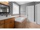 Stylishly decorated bathroom with a tub and decorative wallpaper at 1633 Lakestone Village Ln, Fuquay Varina, NC 27526