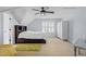 Bright bedroom with a neutral color scheme, featuring a bed with built-in storage and a modern ceiling fan at 1633 Lakestone Village Ln, Fuquay Varina, NC 27526