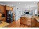 Spacious kitchen with wood cabinets, granite countertops, and stainless steel appliances at 1633 Lakestone Village Ln, Fuquay Varina, NC 27526