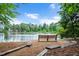 Scenic lake view with a wooden bench, providing a relaxing outdoor community space at 1633 Lakestone Village Ln, Fuquay Varina, NC 27526