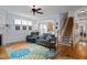 Inviting living room with wood floors, a colorful rug, comfortable seating, and access to the stairs at 1633 Lakestone Village Ln, Fuquay Varina, NC 27526