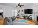 Cozy living area with built-in shelving, hardwood floors, and an inviting gray couch at 1633 Lakestone Village Ln, Fuquay Varina, NC 27526