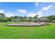 Community playground with swings, slides, and play structures, surrounded by green space and homes at 1633 Lakestone Village Ln, Fuquay Varina, NC 27526