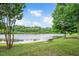 Relaxing pond view featuring a wooden bench and surrounding greenery, ideal for enjoying nature at 1633 Lakestone Village Ln, Fuquay Varina, NC 27526