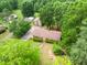 Aerial view of charming home with lush surrounding trees, long driveway, and two-car garage in a quiet neighborhood at 1822 Routh Rd, Burlington, NC 27217