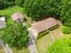 Aerial view of the brick home, detached garage, and lush greenery surrounding the property at 1822 Routh Rd, Burlington, NC 27217