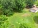 Aerial view of massive backyard with mature trees, home with deck and detached garage at 1822 Routh Rd, Burlington, NC 27217