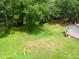 Aerial view of vast grassy backyard, showcasing privacy and ample space, featuring a single story house at 1822 Routh Rd, Burlington, NC 27217