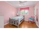 Charming bedroom with wood floors, rocking chair and soft pink walls and accents at 1822 Routh Rd, Burlington, NC 27217