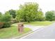 Property featuring a brick mailbox, a long driveway, and a manicured front lawn at 1822 Routh Rd, Burlington, NC 27217