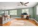 Bright living room with hardwood floors, modern ceiling fan, computer desk and dining area at 1822 Routh Rd, Burlington, NC 27217