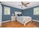 Spacious main bedroom with wood floors, white furniture, blue accents, and a ceiling fan at 1822 Routh Rd, Burlington, NC 27217