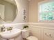 Powder room with round mirror, pedestal sink, and wainscoting at 1833 Creek Oak Circle Cir, Fuquay Varina, NC 27526