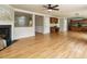 Open concept living room featuring hardwood floors, a fireplace, a ceiling fan, and neutral paint colors at 1833 Creek Oak Circle Cir, Fuquay Varina, NC 27526