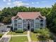 Aerial shot of a multi-story residential building with balconies, parking area, and lush surroundings at 1912 Parkside Village Dr, Clayton, NC 27520