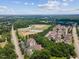 Aerial view of neighborhood featuring homes, baseball fields, playground, and mature trees at 1912 Parkside Village Dr, Clayton, NC 27520