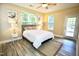 Cozy bedroom featuring stylish flooring, a ceiling fan, a large window, and a convenient door to the outside at 1912 Parkside Village Dr, Clayton, NC 27520