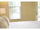 Bright bedroom shows a comfortable bed with plush pillows and natural light coming through large windows at 1912 Parkside Village Dr, Clayton, NC 27520
