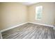 Neutral-toned bedroom featuring a window and stylish, wood-look flooring at 1912 Parkside Village Dr, Clayton, NC 27520